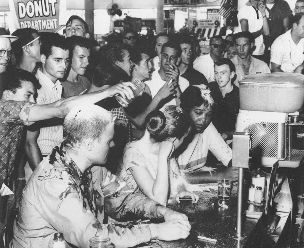 This is the Woolworth Lunch Counter Sit-in that occurred in Jackson, Mississippi in 1963 to protest a white-only diner. Notice 2 of the 3 people being harassed are in fact white.