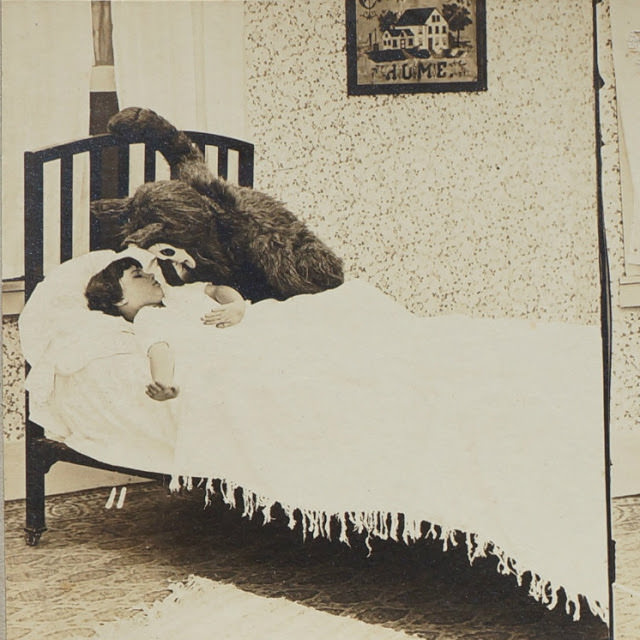 This staged picture, which is part of a set, shows a young girl sleeping with a version of the boogie man about to wake her up in the US in 1931.