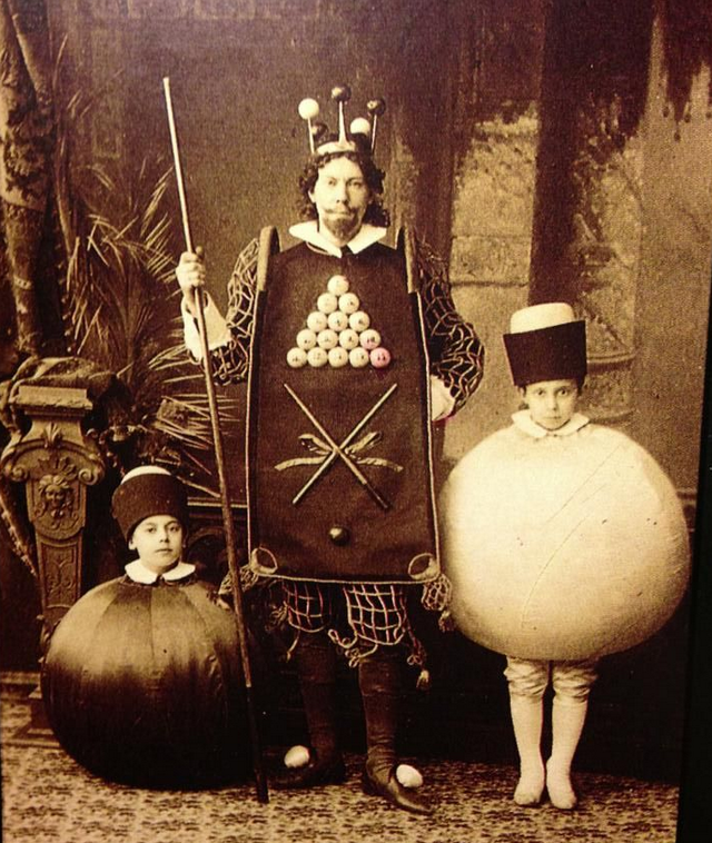 A man dressed as the king of billiards with his 2 sons dressed as the cue ball and 8 ball in Russia in 1886.