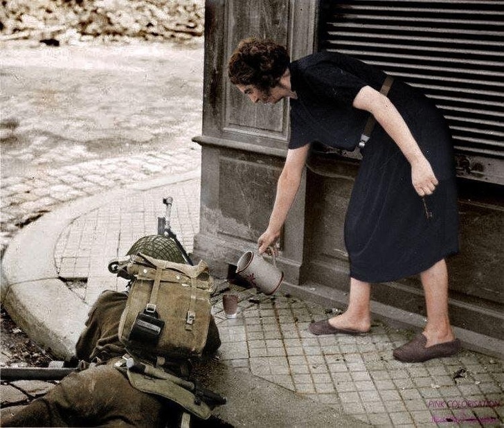 A French woman pouring a hot cup of tea for a British soldier fighting in Normandy, 1944