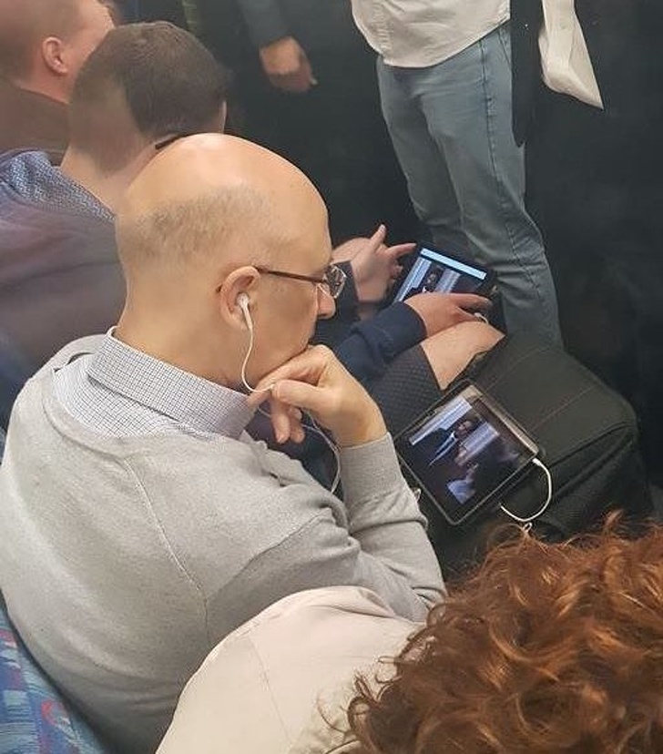 These 2 men sitting beside each other are watching the same show.