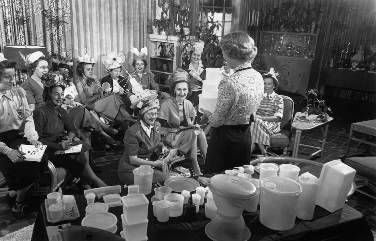 Ladies wear special container hats during a Tupperware party in the US in 1950.