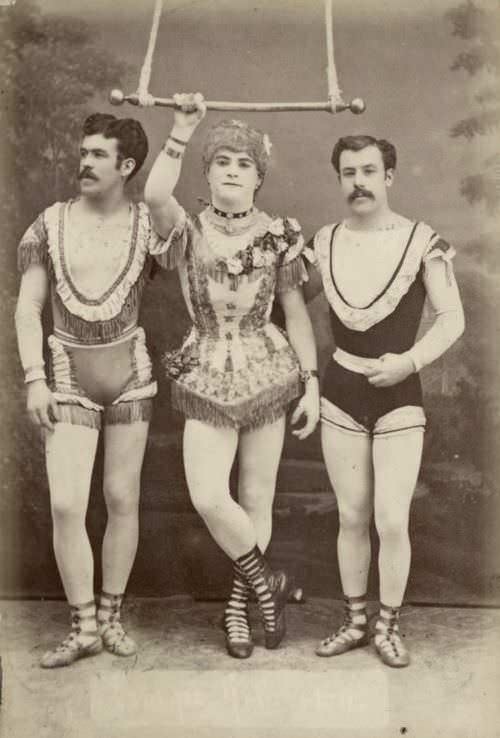 3 High flying circus acrobats pose for a picture in costume in Germany in 1884. One is dressed as a woman and would pretend to be one during the performance showing surprising strength.