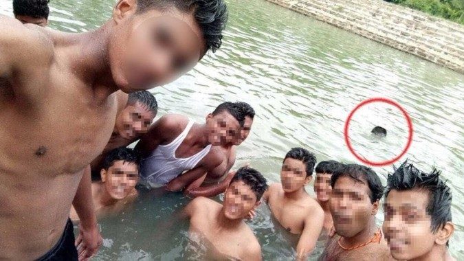 In this photo, a boy is seen drowning in the background. A young boy drowned while on a class trip. The boys in the front didn’t notice him drowning while taking a selfie. Drowning can be very quiet and easy to miss, unlike what you see on TV.