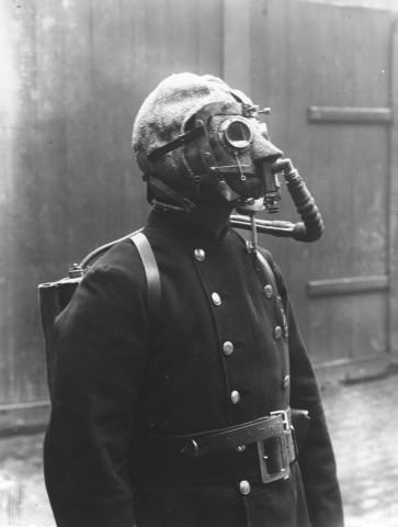 An early gas mask in Germany in 1912. That is not his head, but part of the hood around the mask.