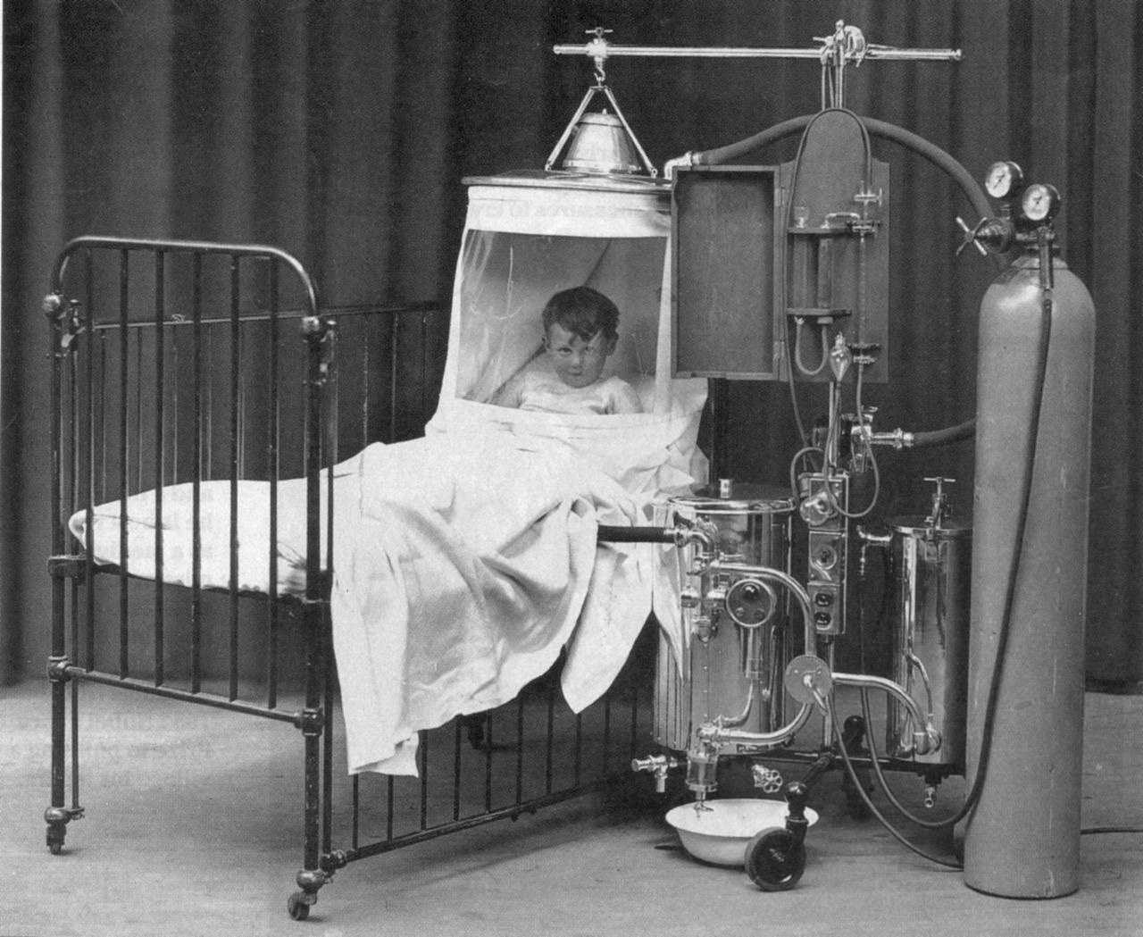 A kid in an oxygen apparatus in the US in 1930. Zoom in on the kid.