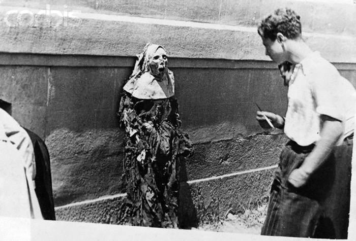 Republican supporters toy with the corpse of a nun they dug up during the Spanish Civil War in 1936. They also desecrated many Catholic churches and destroyed key artifacts.