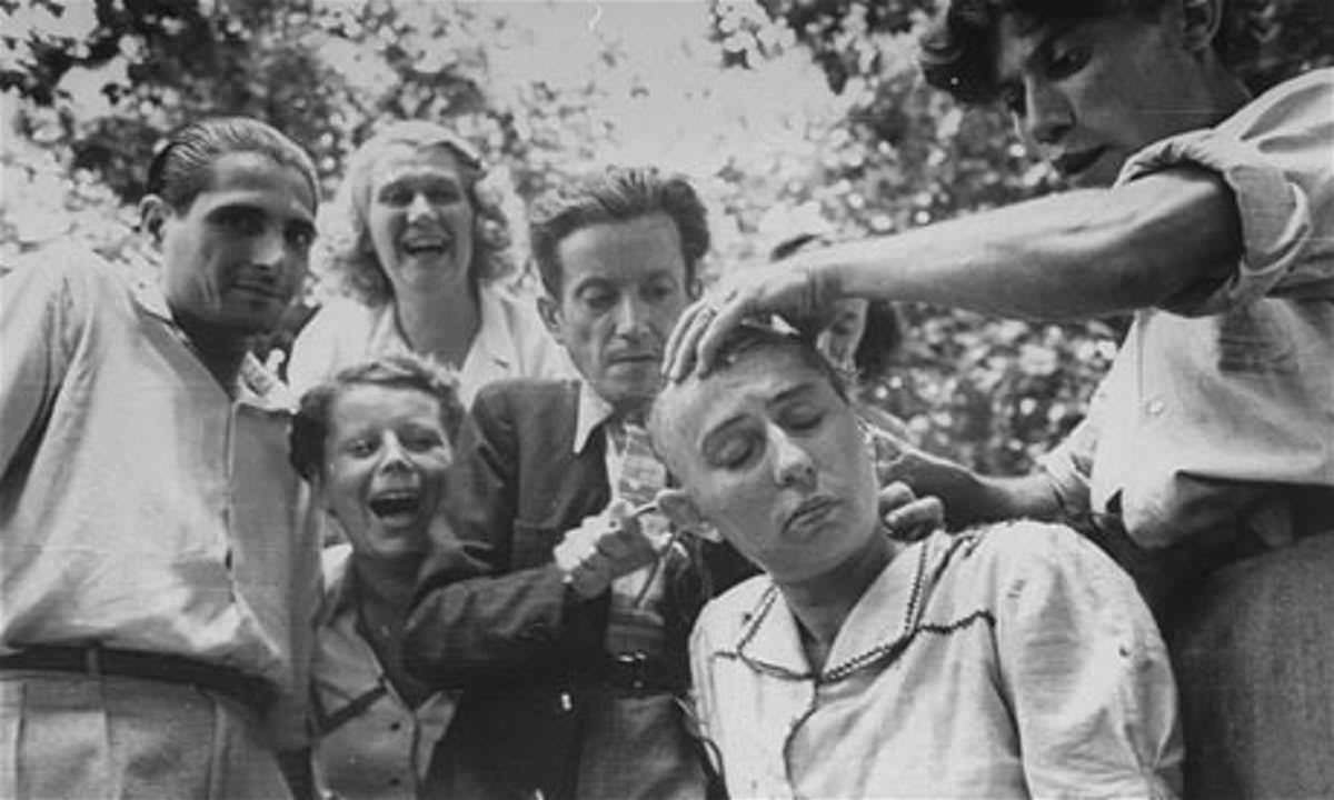 People jeer as a woman has her head shaved for having a relationship with a Nazi after the liberation of Marseilles, France in 1944. She would be stripped to her underwear, have the Swastika written on her forehead and paraded in the center of town shortly afterwards.