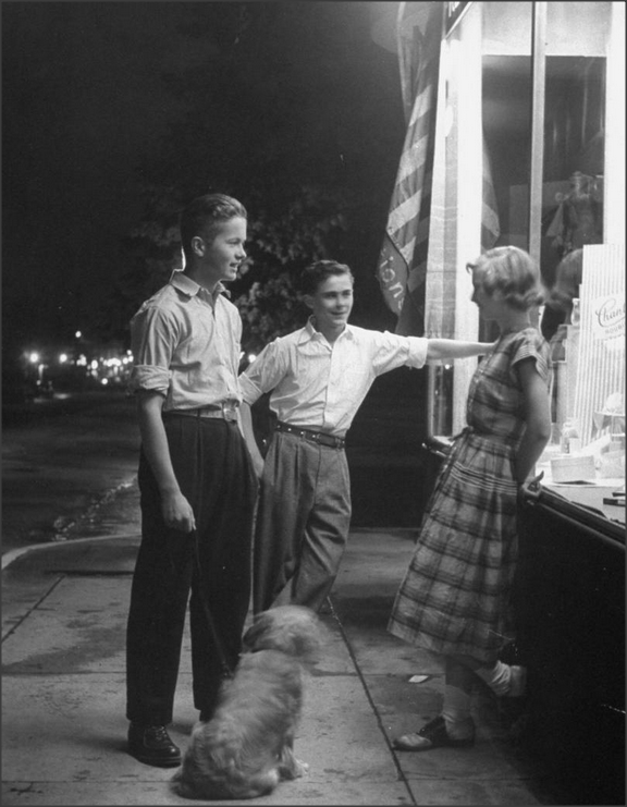 2 Teenage boys start talking to a girl from school while taking a dog for a walk in the US in 1948.