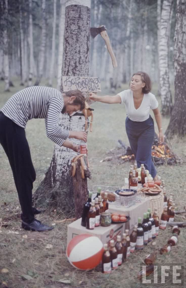 A couple prepares a picnic in Russia in 1964. They were called Soviet Hippies in the article about daily Soviet life. Notice the hotdog shaped man stabbed to the tree? The more you look at this picture, the weirder it gets.