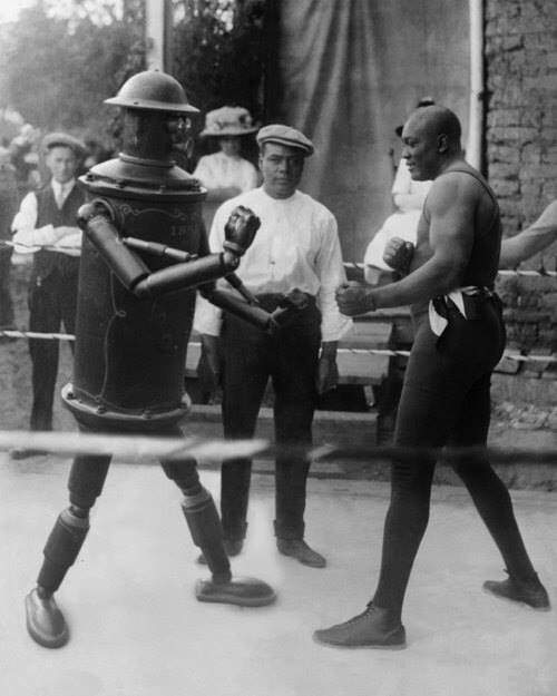 Boxing champion Jack Johnson pretends to spar with a movable robot in the US in 1910.