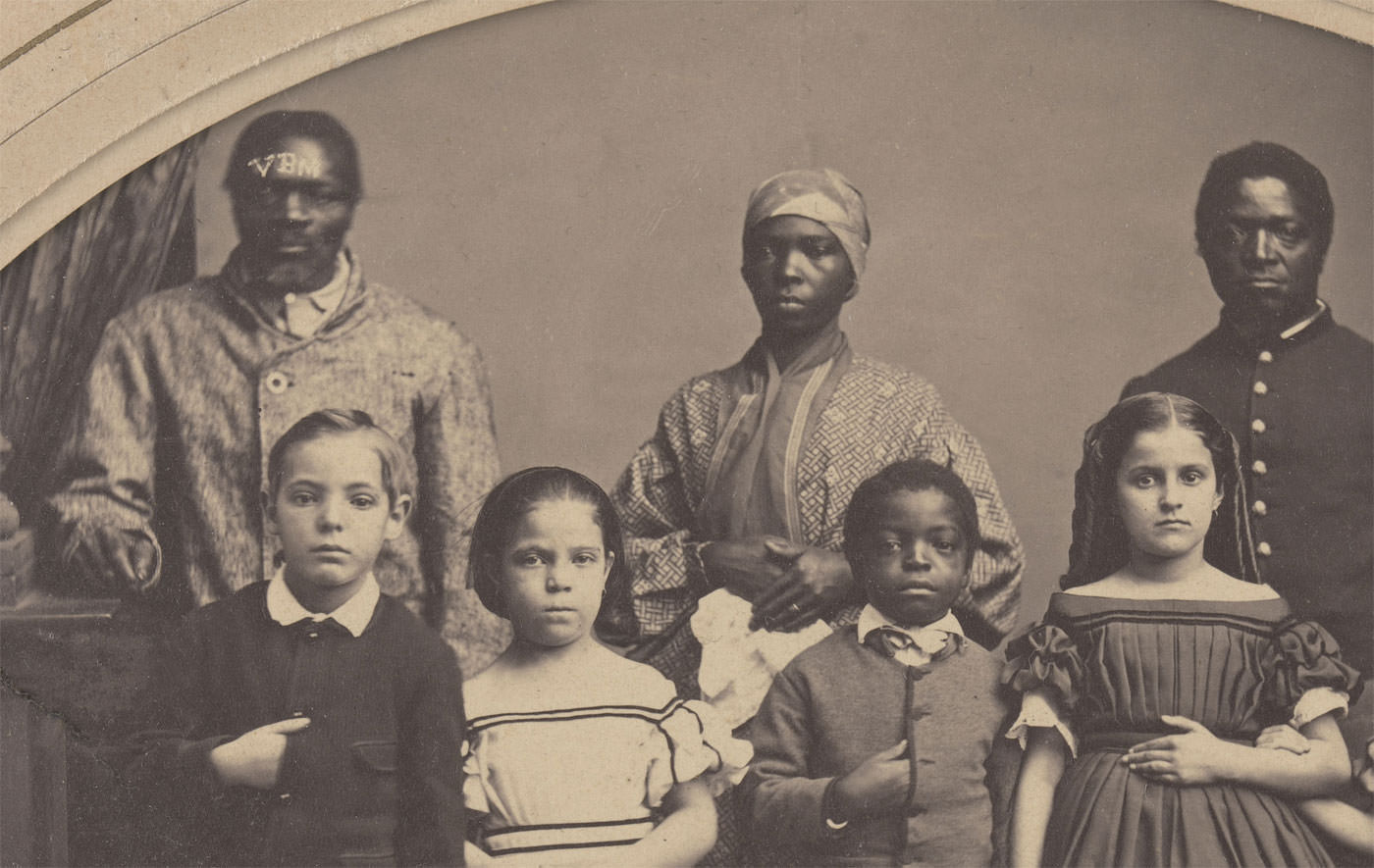 Former slaves from Louisiana pose with school children of a school created by the man who freed them, Colonel George H. Banks, in New York, US in 1863.