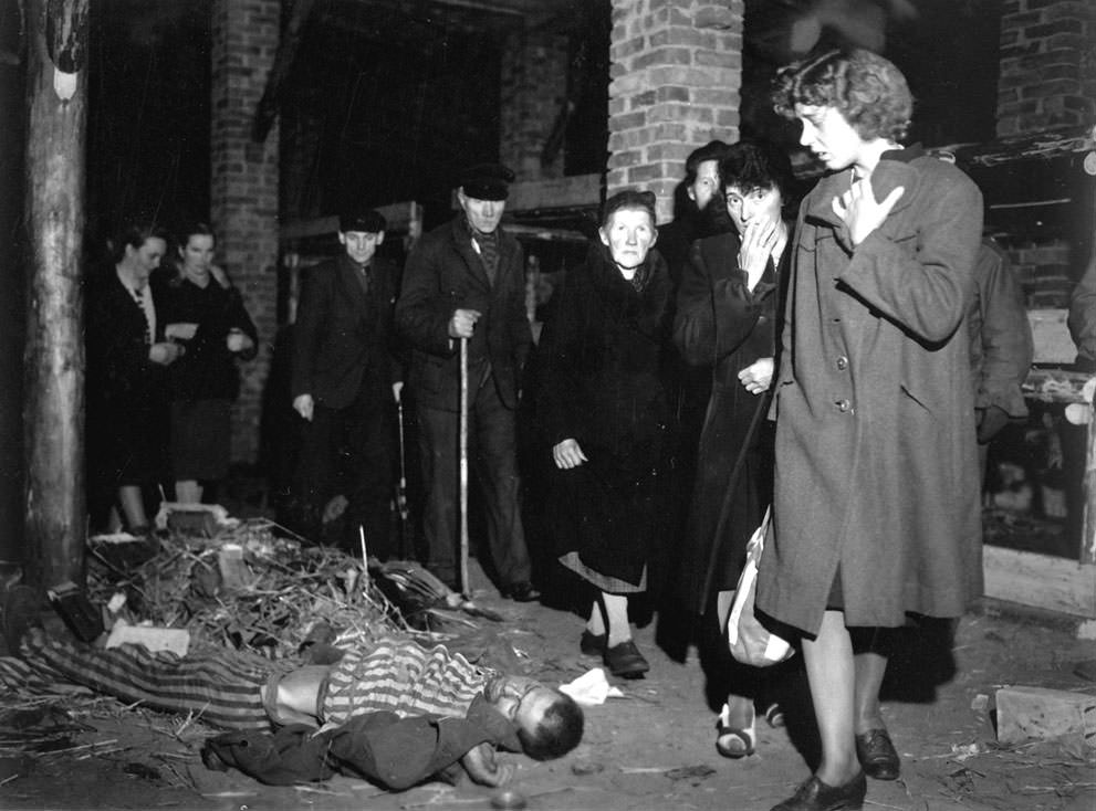 Citizens of Ludwigslust, Germany, inspect a nearby concentration camp under orders of the 82nd Airborne Division in preparation for its cleanup on May 6, 1945. Bodies of victims of the German concentration camps were found dumped in pits in the yard with one pit containing at least 300 bodies. Many victims were killed before the guards ran off, setting fire to areas as well. When the US forces found many of the concentration camps in Germany, they were shocked the locals in towns near them usually claimed they didn't even know it existed. As a response to that, the US forced the local businesses to supply food and rations for the survivors, then forced the citizens to clean up the dead at the camps. This put the bodies of the victims of the holocaust face to face with German citizens who either supported the camps or were complicit in their operations. The faces on the ladies on the right is what many of the citizens experienced after seeing these horrors up front. It is important to note many Germans did not agree with the Nazis. In fact, a lot of German citizens who survived the war who had to clean up such camps had severe breakdowns and some even committed suicide.