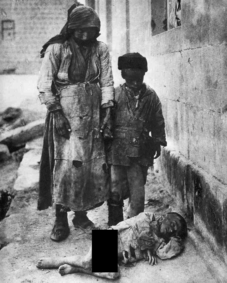 A mother and her son check to see if this fallen child is alive as they are being deported from an area in Turkey during the Armenian Genocide in 1915. The child was alive, but too weak to walk, and like many other starving children during forced relocations at this time, most likely was left to die. The Ottoman Turk forces took over Armenian towns as early as 1914 and forced relocated them throughout WWI and even as late as 1923. They would often just kill the men and starve the women and children. This picture, and a few others like it, were smuggled out to the West, mainly by Swedish missionaries, in an attempt to bring this situation to light throughout the world. The extent of the genocide was not entirely known during WWI, and the allied leaders were busy handling Germany and Austria-Hungary, Russia's internal collapse, mutinies in France, and other issues, allowing the Turks to freely continue the annihilation of the Armenians. Those that escaped being rounded up or killed fled to areas like Syria, often dying on the treacherous journey. All told, it is estimated 1.5 million Armenians were killed. The Ottoman empire collapsed and was dissolved shortly after WWI. The new Turkish state post WWI and even Turkey today refuses to fully acknowledge the genocide ever happened. Unfortunately none of the leaders behind this orchestrated and systematic elimination of a people ever saw justice.