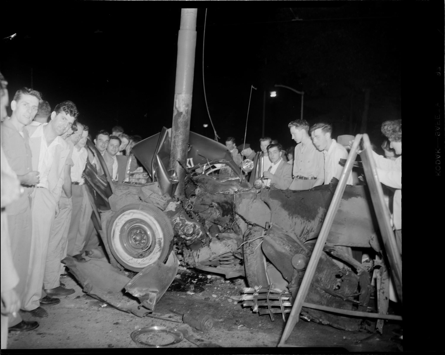 A crowd poses for the camera after a fatal car crash in the US in 1947.