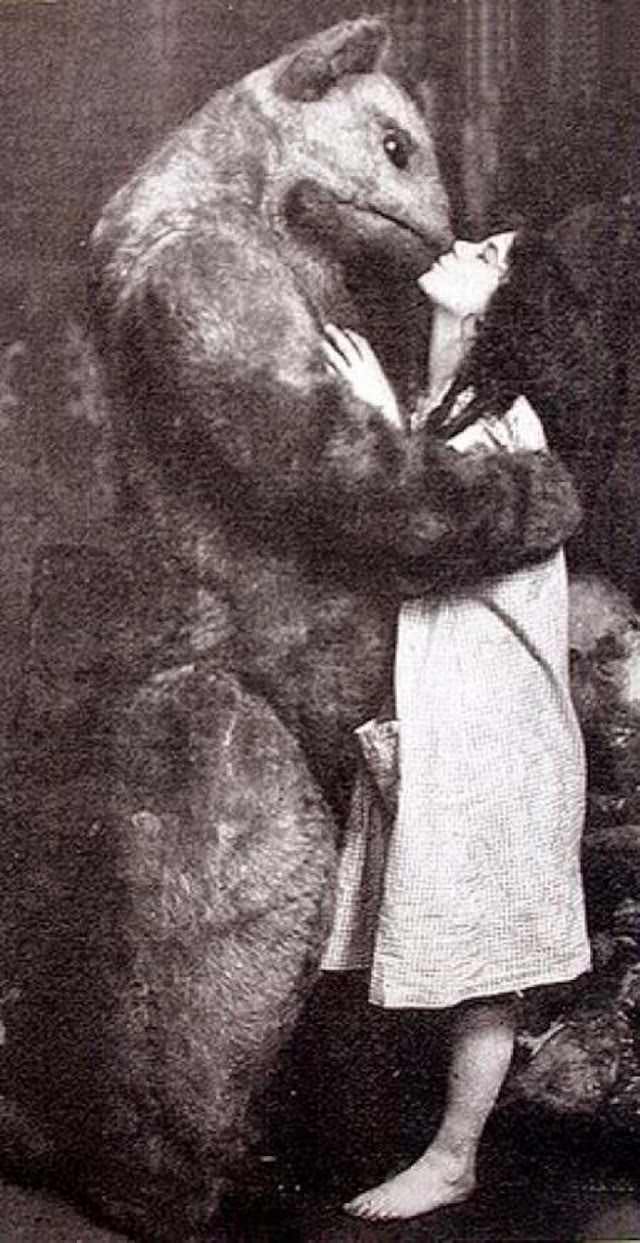 An actress kisses a giant animal character in a play in Moscow in 1909.