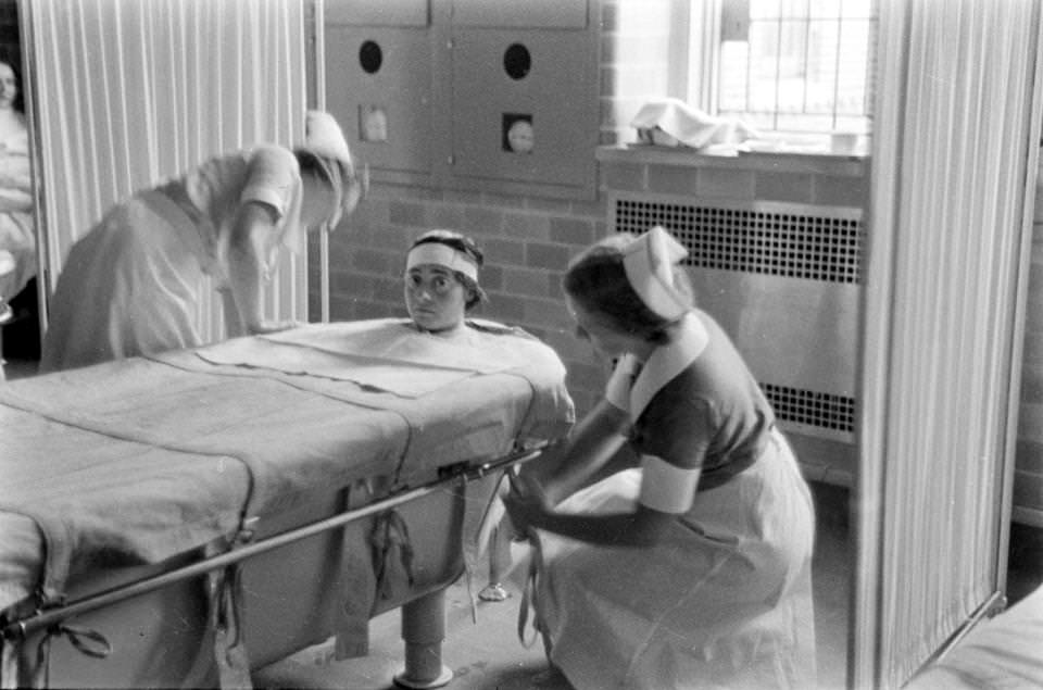 Nurses strap a patient into to a bath for hydrotherapy treatment in New York, US in 1937.