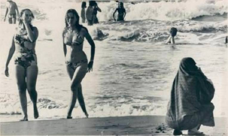 2 Different style of cultures enjoy a day at the beach in Iran in 1976.