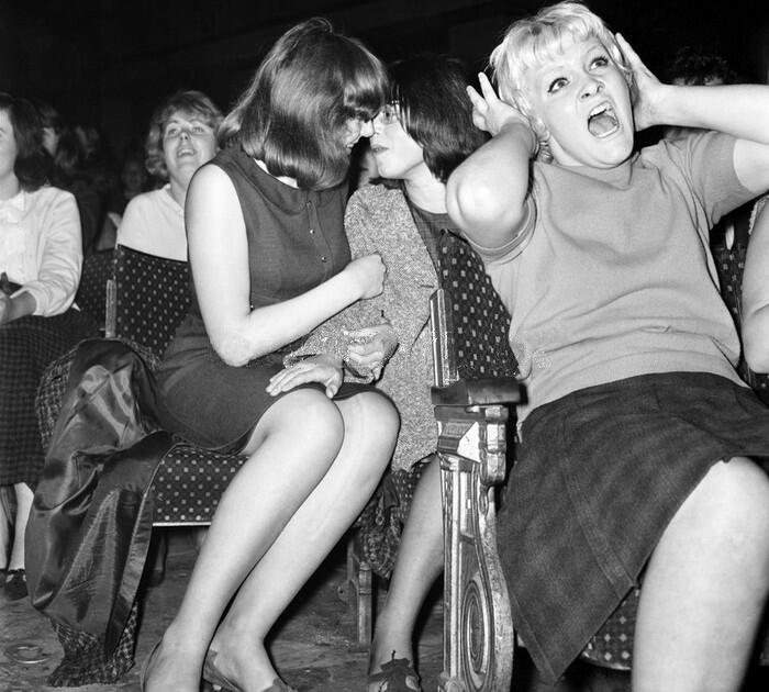 A lesbian couple about to kiss at a Beatles concert in the US in 1964.