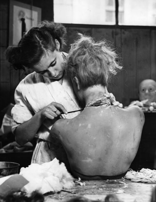A woman works on a doll for a movie in France in 1953.