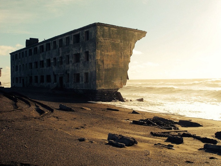 An abandoned apartment building being claimed by the sea in the former fishing village of Kirovsky, Russia