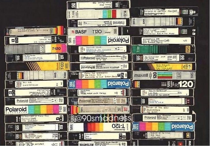 Netflix from the 90's nostalgia era of VHS tapes piled high with markers written on stickers to describe what is on the tape