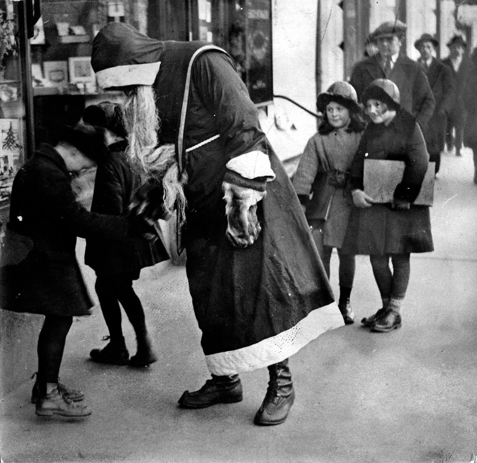 A man dressed as Santa greets excited children in Helsinki, Finland in 1930.