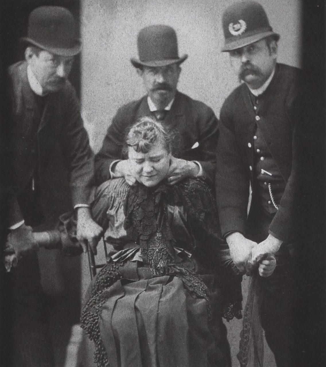 Police officers physically force a woman to get her mugshot taken in NYC, US in 1890.