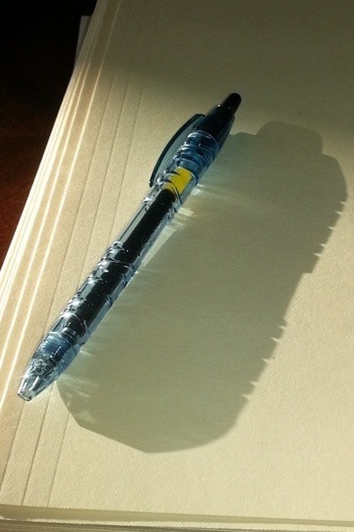 “Pen made of recycled water bottles casts the shadow of a water bottle.”