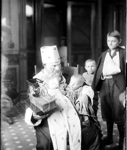 A man dressed as Santa Claus giving gifts to sick children at Cook County Hospital in Chicago, US in 1909.