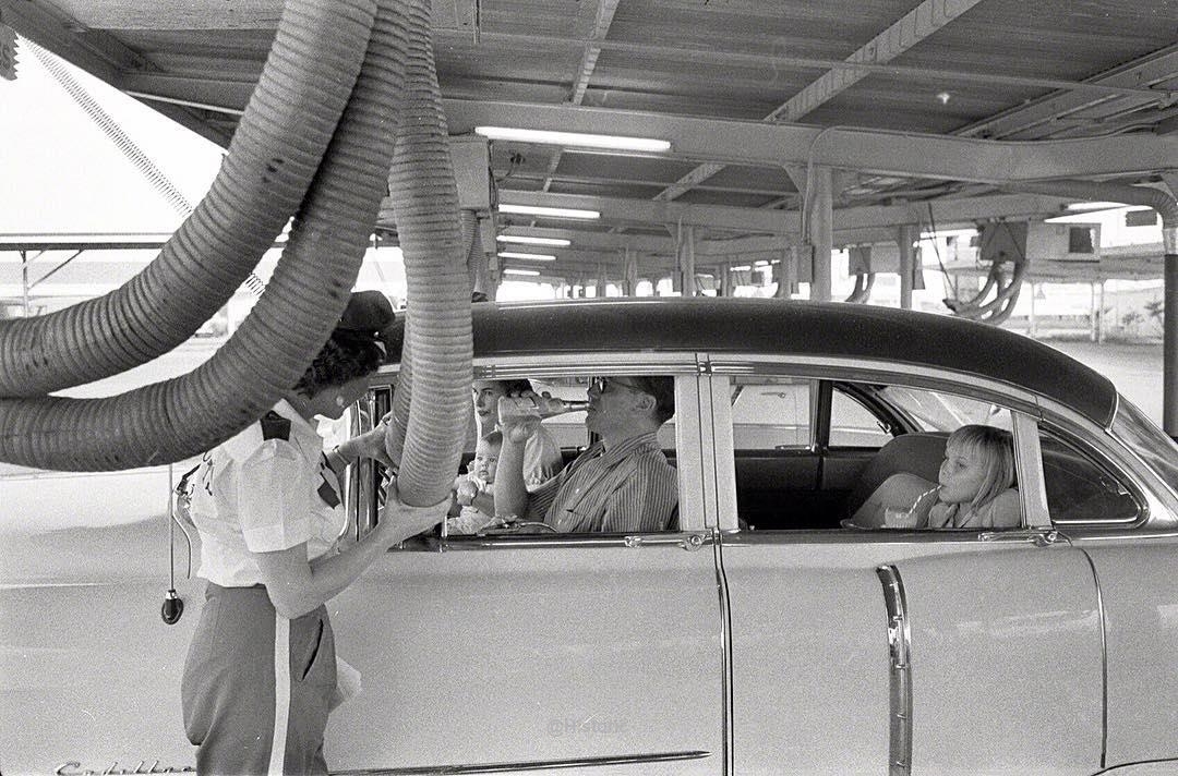 Getting cooled air piped into the car while enjoying a meal at a drive-in restaurant in Houston, Texas 1957