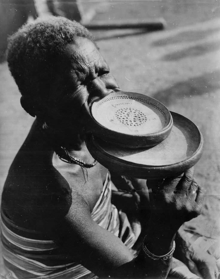 A woman show how she uses plates to stretch out her lips in French Equatorial Guinea in 1972.