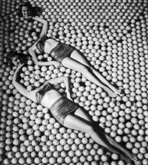 4 Models mess around on a stack of oranges in the US in 1946.