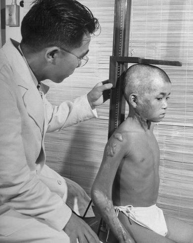 A young boy who survived the atomic bombing of Hiroshima is checked out by a doctor in Japan in 1949.