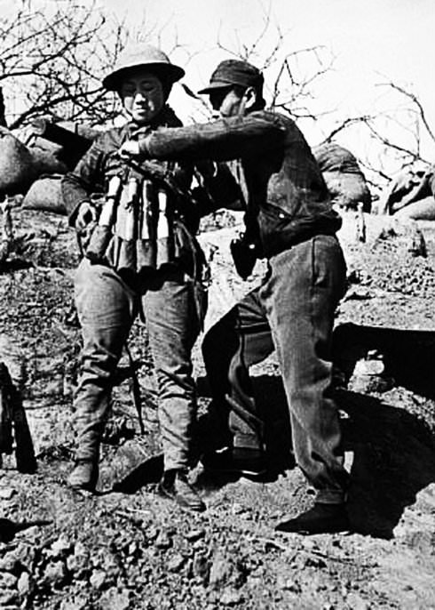 A Chinese soldier prepares a suicide bomber with an explosive vest made out hand grenades for an attack on Japanese tanks at the Battle of Taierzhuang in China in 1938.