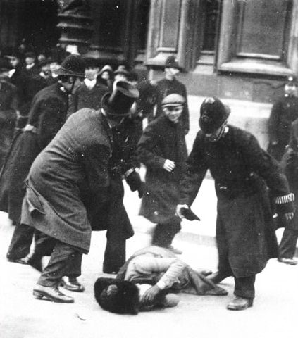 A man tussles with police after they struck a suffragette to the ground during a womens rights march in London, England in 1914.