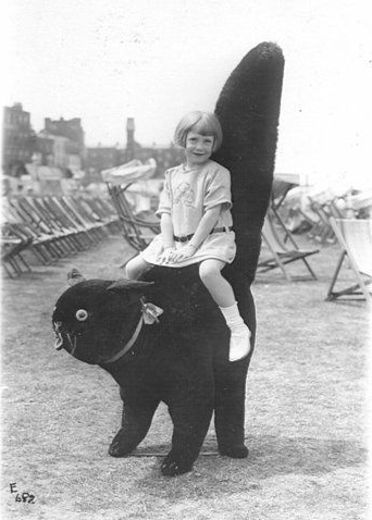 A young girl sitting on a giant cat statue on a beach in New Jersey, US in 1934.