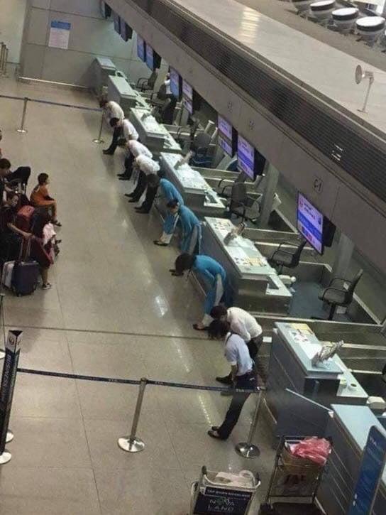 Flight delayed in Japan. Airline employees bow to the passengers to apologize