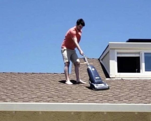 man vacuuming roof