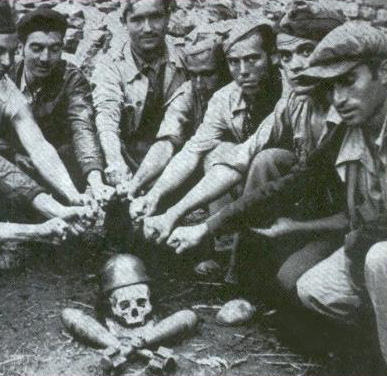 Soldiers solute the symbol for death using a rear skull and 2 mortors during the Spanish Civil War in 1937.