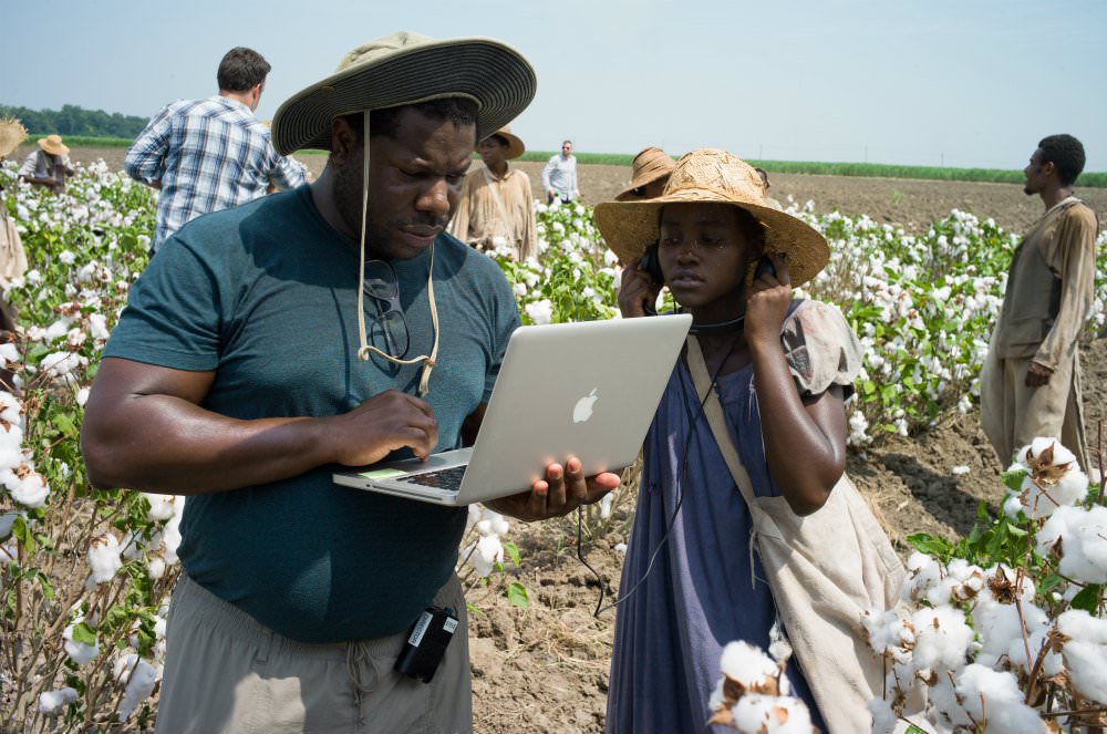 Director Steve McQueen reviewing a scene on a laptop with Lupita Nyong'o for the film 12 Years a Slave in 2013.