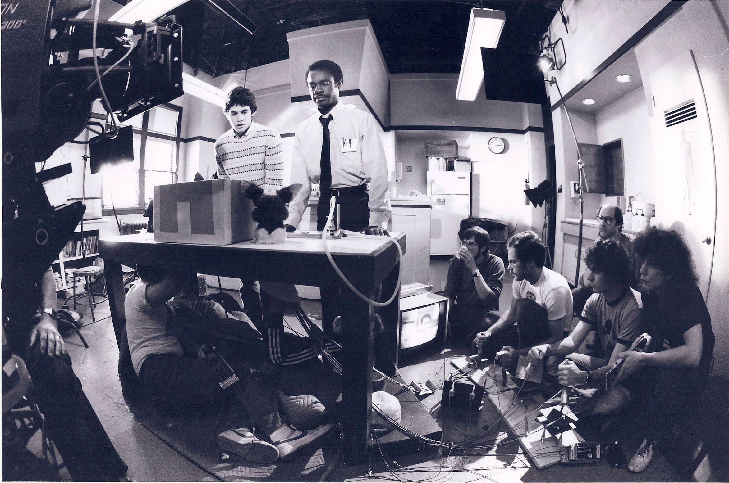 6 Crew members work the controls of the furry creatures while Zach Galligan and Glynn Turman prepare for their scene in Gremlins (1984).