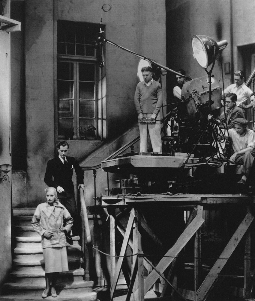 Greta Garbo and John Gilbert preparing to film a scene for Queen Christina (1933).