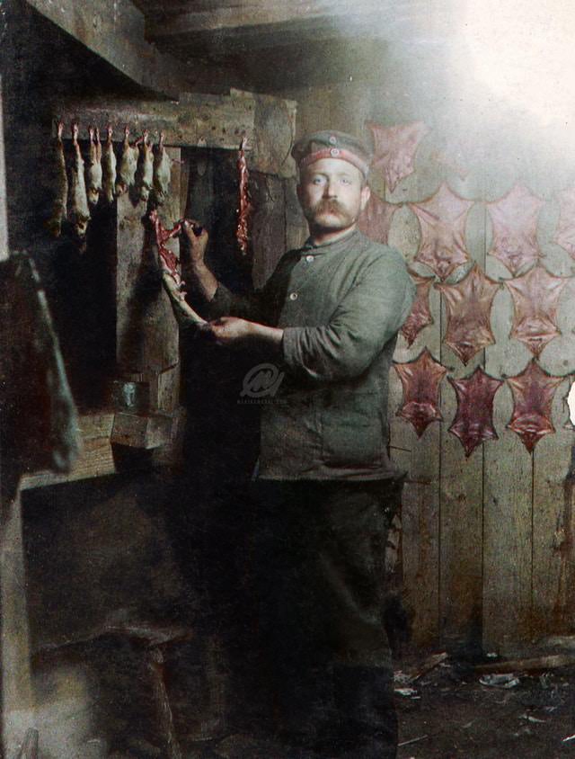 A Prussian Landwehrmann tanning rat skins in a dugout, WWI.