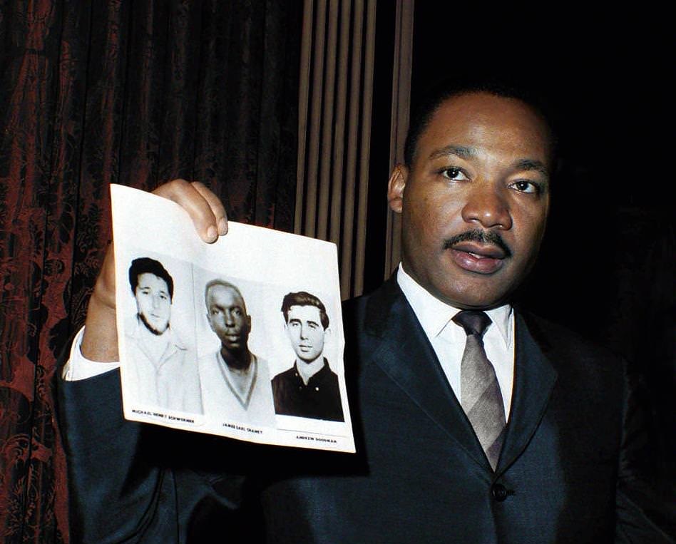 The 'Mississippi Burning' Murders - Martin Luther King holds up photos of the three young civil rights workers murdered in Mississippi the previous summer. Dec. 4, 1964 in New York City.
