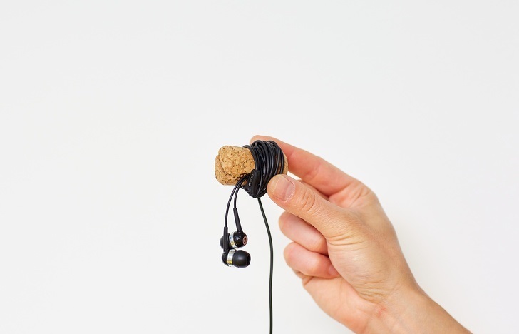 You can use a wine cork to make a small earphone holder.

1. Make cuts on both sides of the cork;
2. Put the wires into the cuts;
3. Wind the wire around the cork;
4. Attach the plug to the second cut.