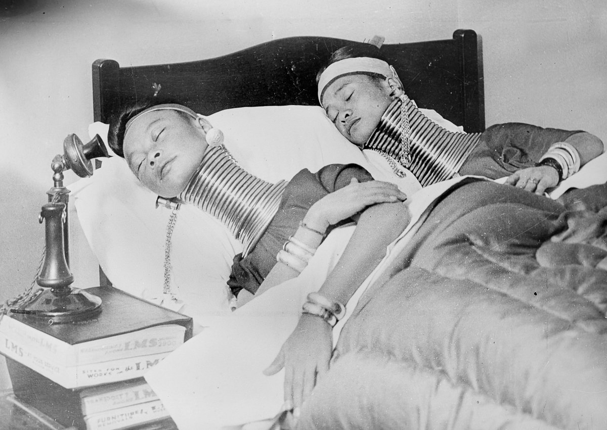 Paduag women from Burma showing their extended necks while resting during a visit to London, England in 1935.