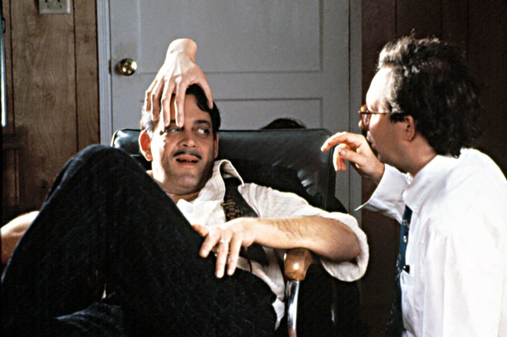Director Barry Sonnenfeld (right) prepares Raul Julia for a scene in The Addams Family (1991).