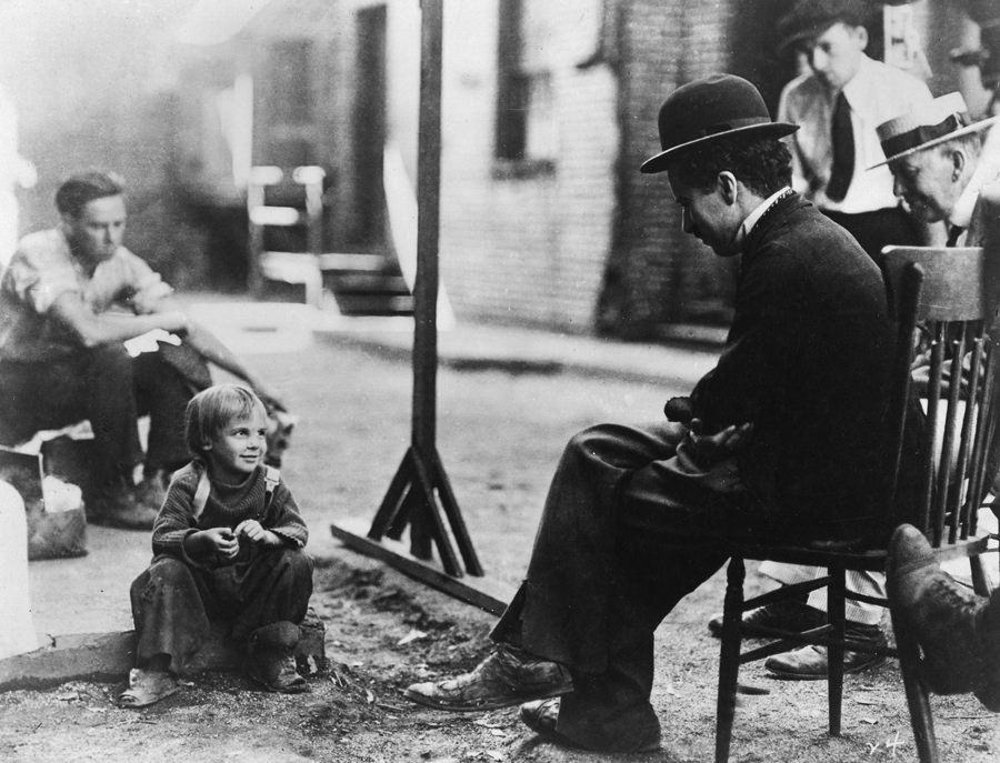 Charlie Chaplan and crew members have a cute moment with Jackie Coogan between scenes of The Kid (1921).