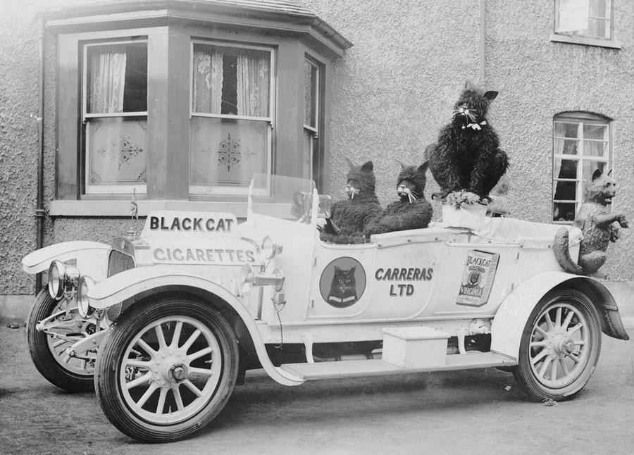 A customized car advertises Black Cat cigarettes, circa 1915